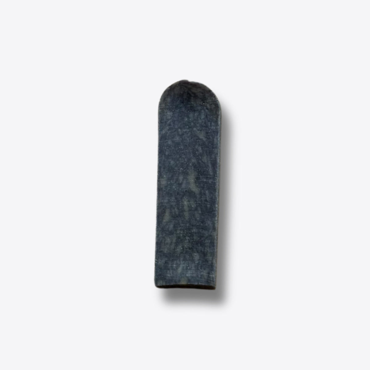 A single blueberry milk chew, a hard blue-grey bar of pressed milk, on a white background