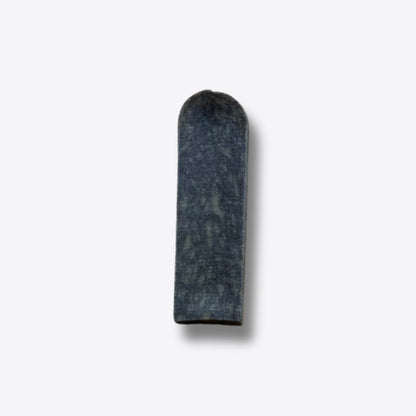 A single blueberry milk chew, a hard blue-grey bar of pressed milk, on a white background