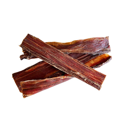Strips of air-dried beef biltong for dogs on a white background