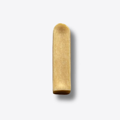 A single mango milk chew, a hard golden bar of pressed milk, on a white background
