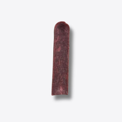 A single cranberry milk chew, a hard deep red bar of pressed milk, on a white background