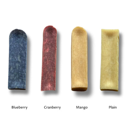 Four chews side by side, the blueberry, cranberry and mango milk chews next to the plain yak chew, labelled by flavour