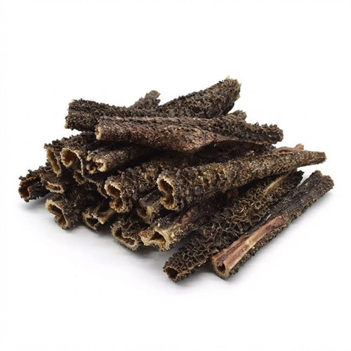 A pile of dried beef tripe sticks for dogs, showing the honeycomb texture