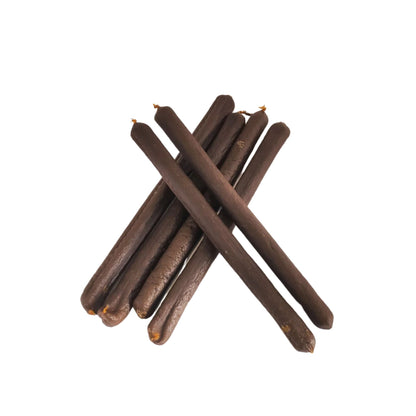 Six dried pork sausages for dogs stacked on a white background